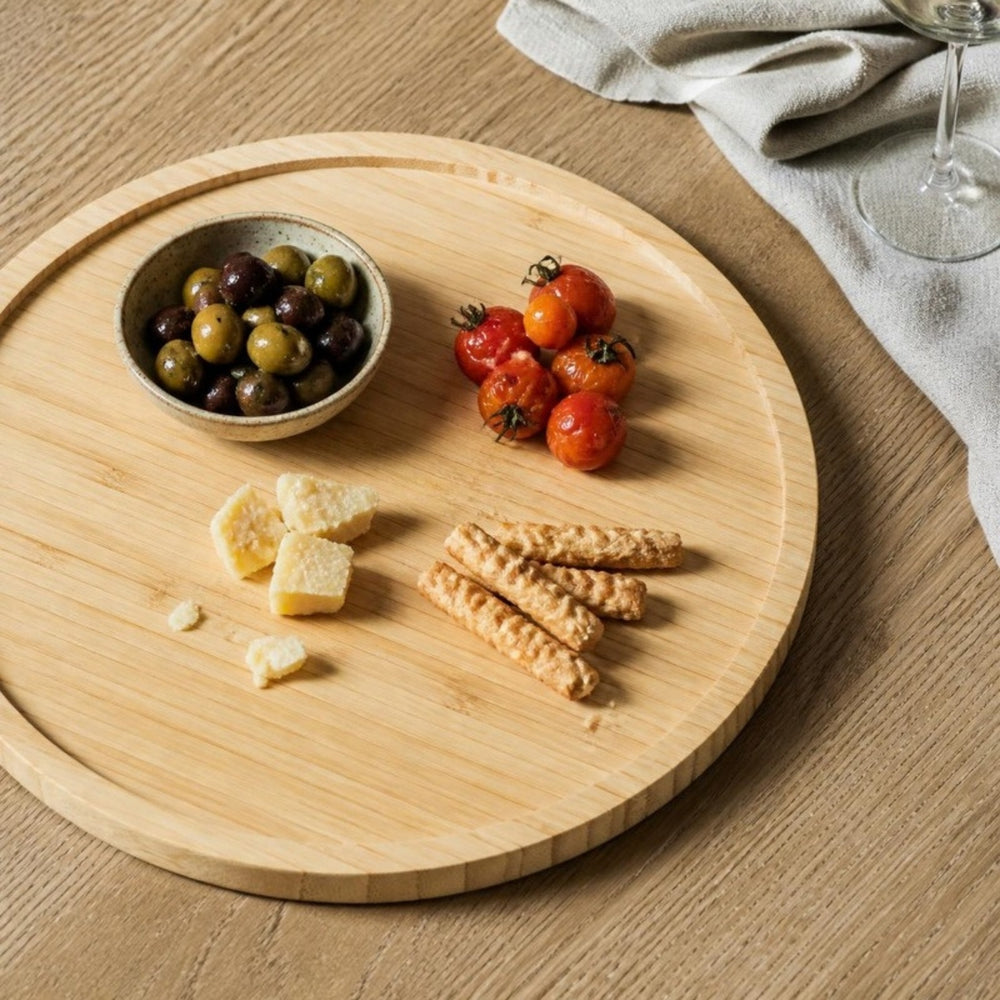 Bamboe draaiplateau met tapas van bovenaf op een eiken eettafel