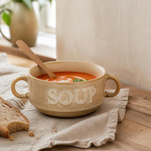 Crème Soup soepkom met tomatensoep en houten lepel op een linnen servet
